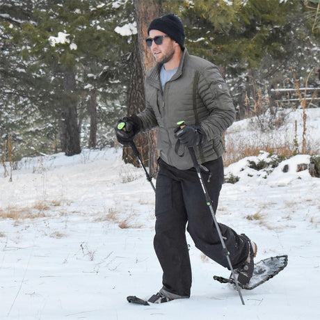 Man snowshoeing through deep snow wearing Menβs Elite 25 ultralight snowshoes