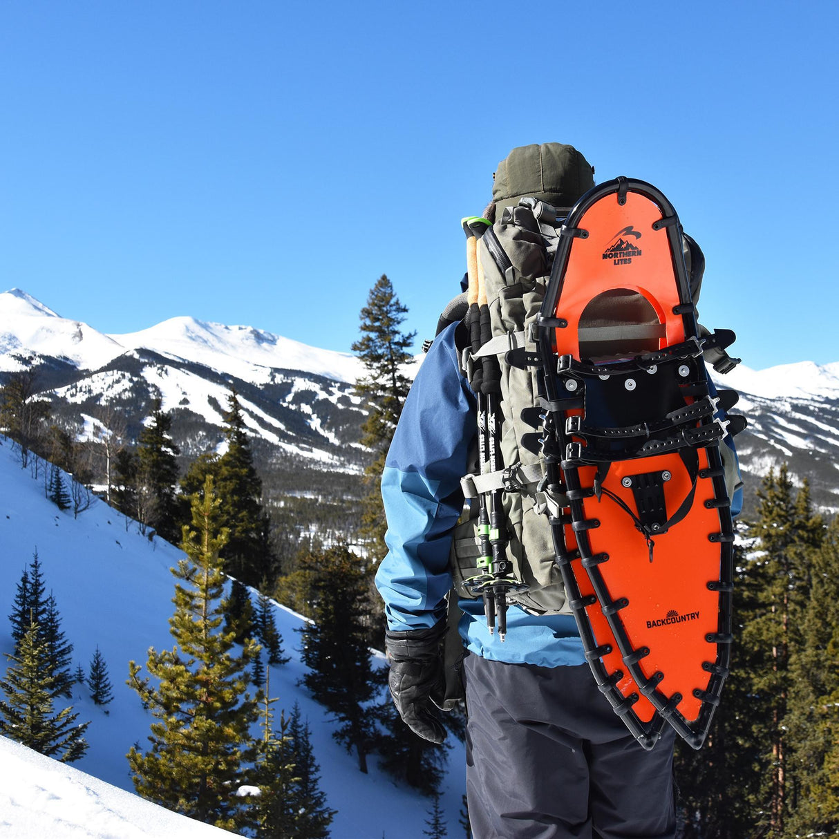 Hiker wearing Backpacker ultralight snowshoes trekking through snowy forest