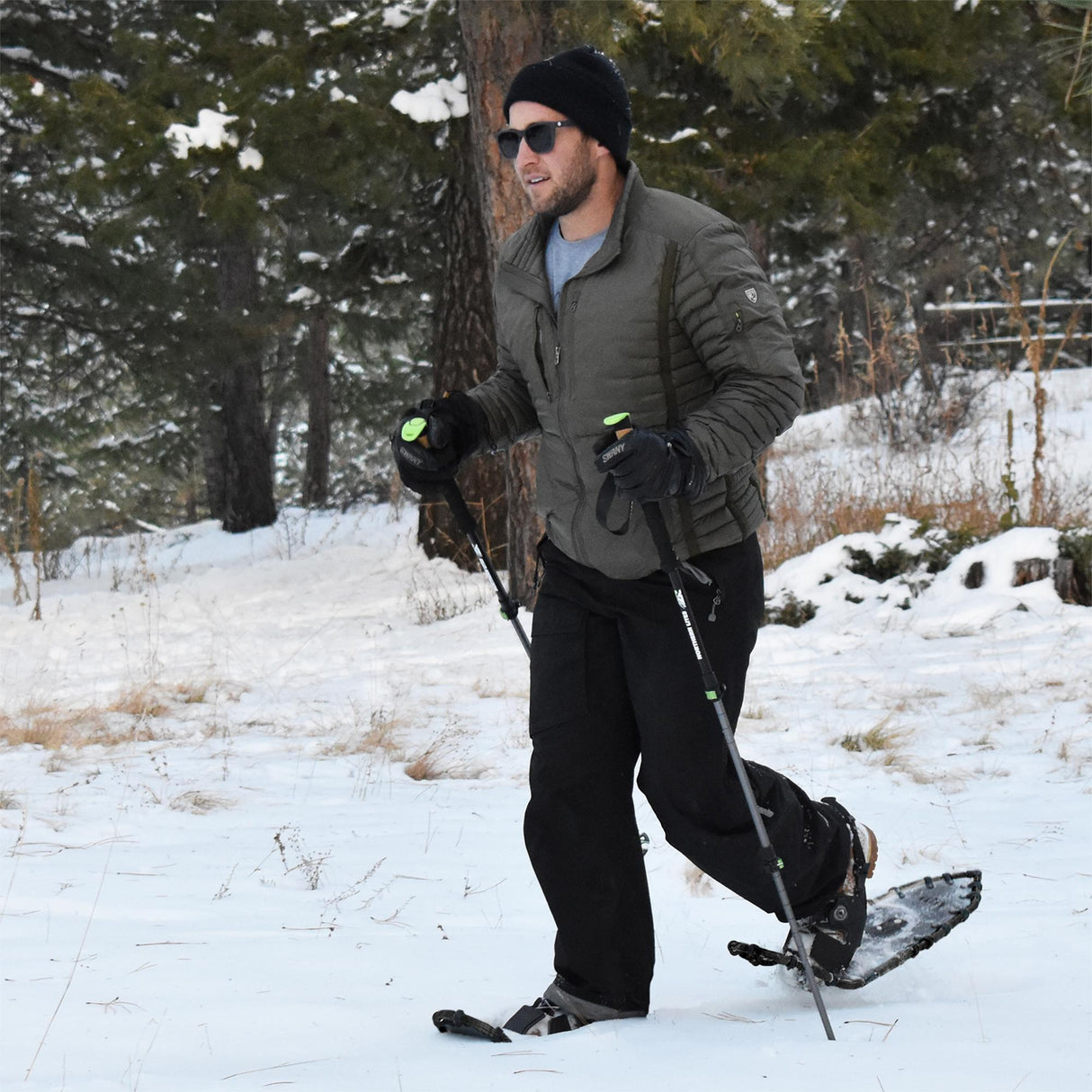 Man using Men’s Elite 25 snowshoes and trekking poles on snowy trail
