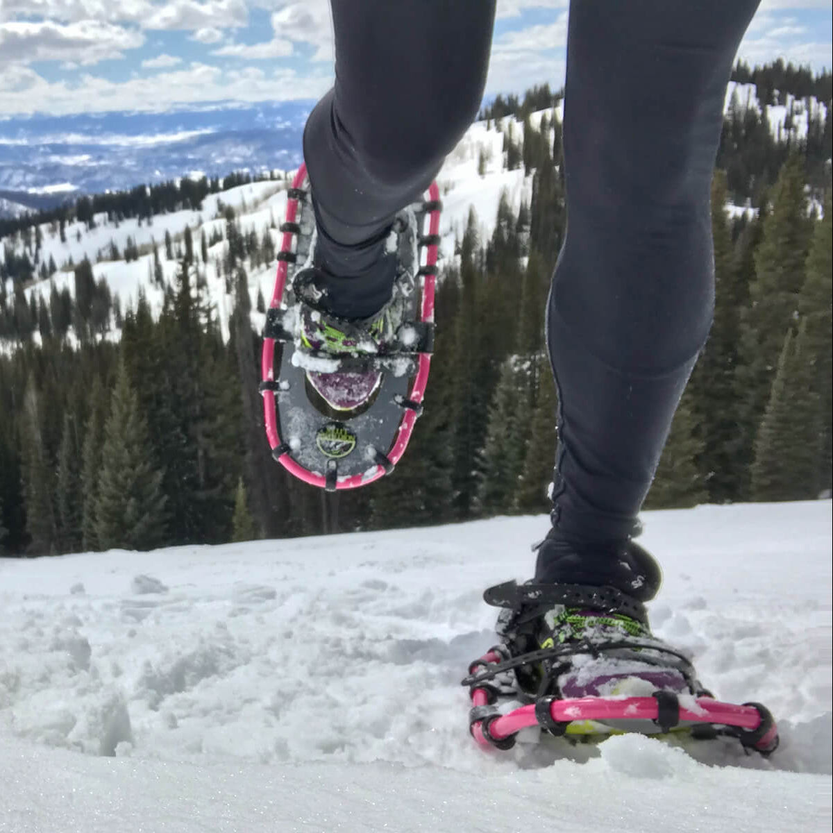 Snowshoe racer crossing snowy trail during winter running event