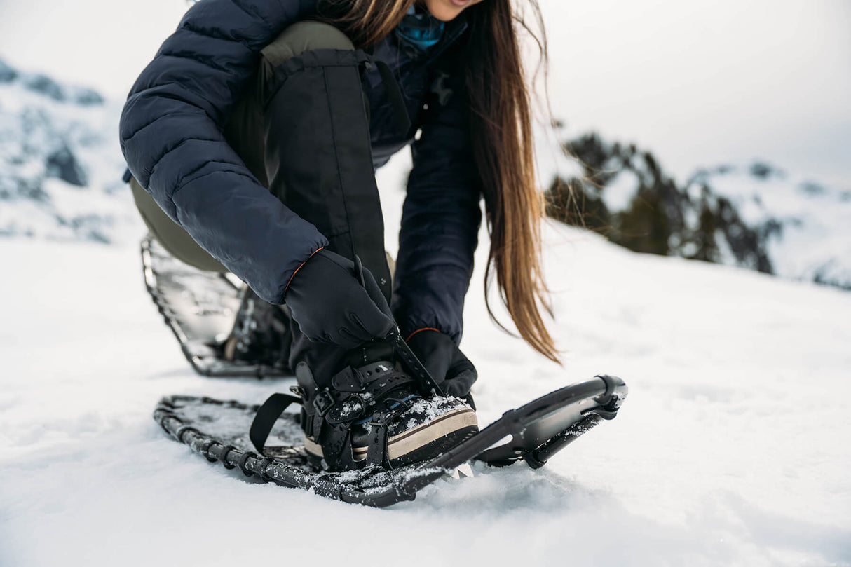 Snowshoer trekking uphill in Timber Wolf 25–33 snowshoes in deep snow